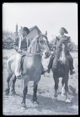 2 cavaliers en costume sur leurs chevaux, devant une assemblée lors d'un défilé hippique folklorique