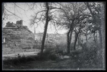 1 vue  - La Roche Maurice.- Vue éloignée du château et de l\'église de la Roche-Maurice, arbres au premier plan (ouvre la visionneuse)